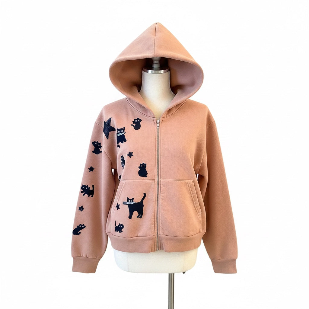 A Brand Called California peach cropped zip-up hoodie with black cat and star appliques. Features a front zipper and kangaroo pocket.