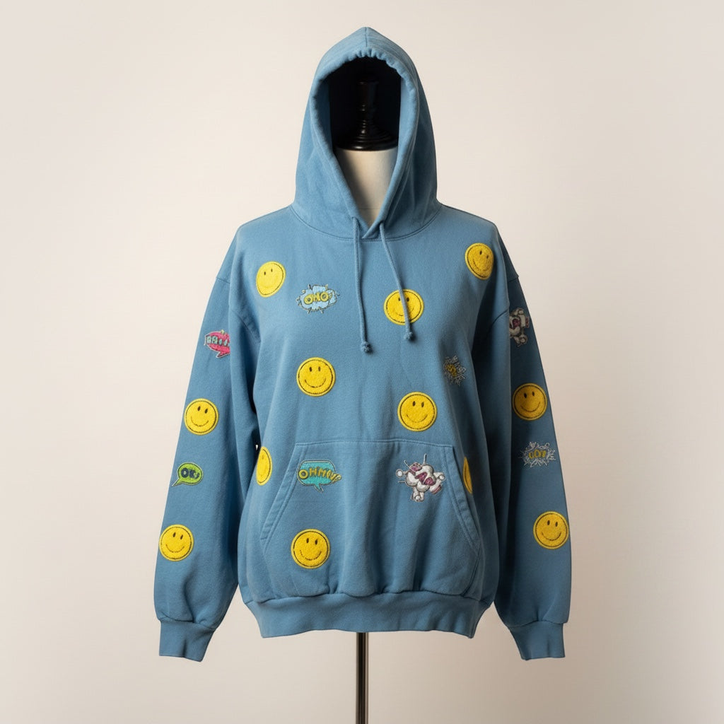 A Brand Called California blue cotton hoodie with all-over yellow smiley face and graphic print. Features hand-sewn details.