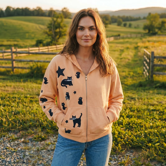 A Brand Called California cream cropped zip-up hoodie with black cat and star hand sewn embroidery design. Model wears jeans outdoor